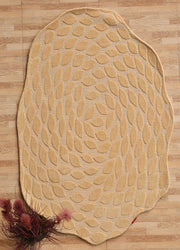 The RAMSHA HOME Autumn Leaf Organic Shaped Rug Beige CMN 103, featuring a swirling leaf pattern, lies on a wooden floor. Burgundy dried flowers in the corner add warmth to the cozy decor.