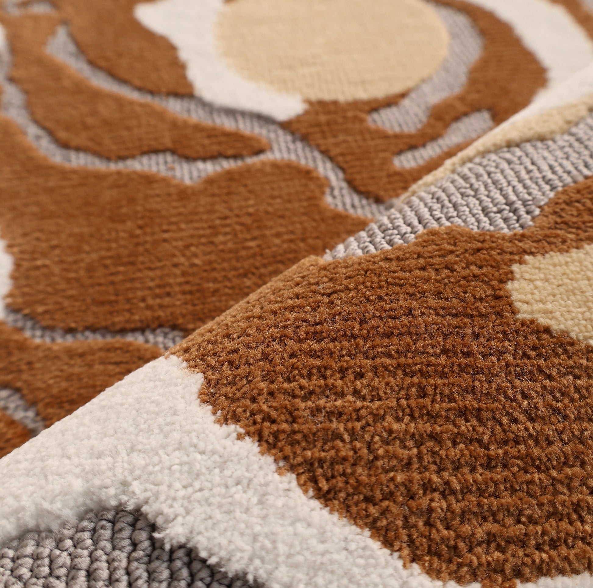 Close-up of the Modern Round Abstract Rug CMN 104 by RAMSHA HOME, featuring a soft, plush texture and an abstract pattern in brown, beige, white, and gray tones. Raised and flat areas enhance its contemporary, organic design.