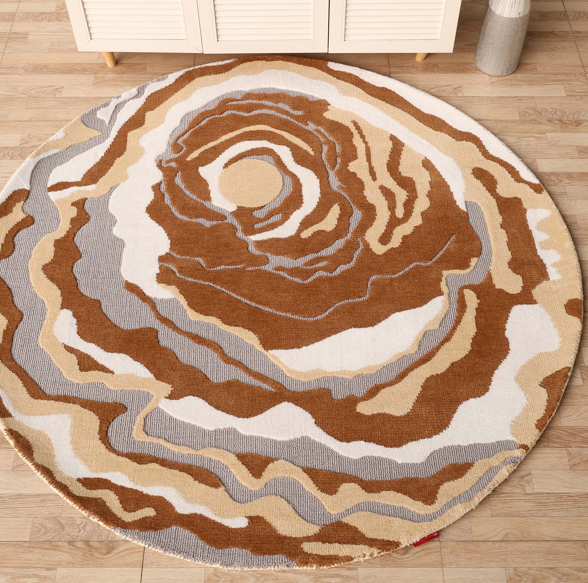 The RAMSHA HOME Modern Round Abstract Rug CMN 104 features layered brown, beige, cream, and gray patterns resembling topographic contours, adding a contemporary touch to light wood floors.