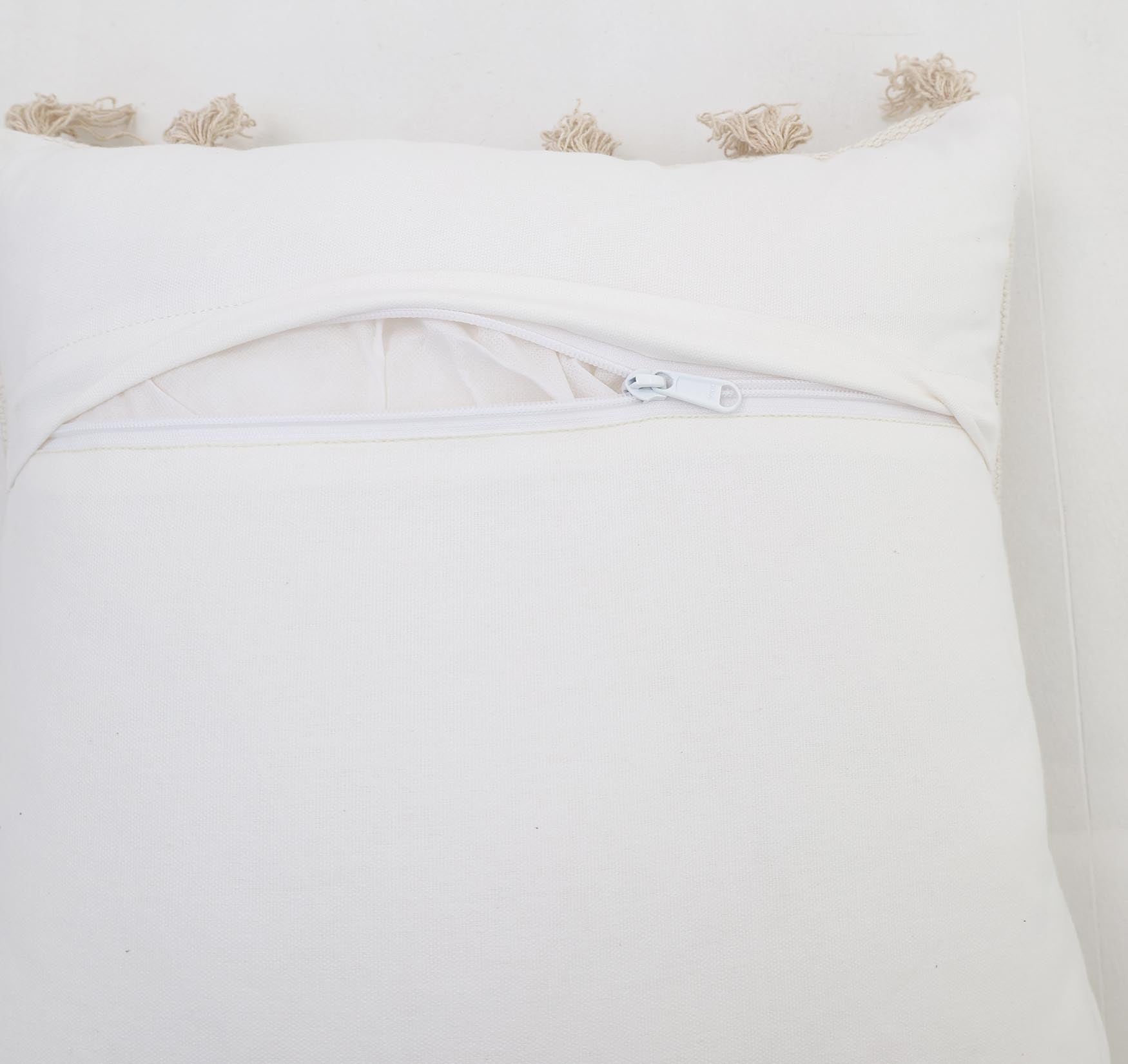 A close-up of the Ramsha Home Cotton Cushion Natural & White Color - CS 299 (45x45cm) shows beige tassels, an open zippered back, and inner lining—ideal as a stylish home decor piece from this luxury UAE brand.
