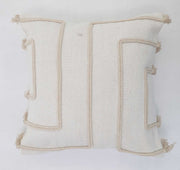 The Ramsha Home Cotton Cushion Natural & White Color - CS 299 (45x45cm) features beige raised geometric patterns and tassels, blending elegance with modern home decor—luxury furnishings from a top UAE brand.