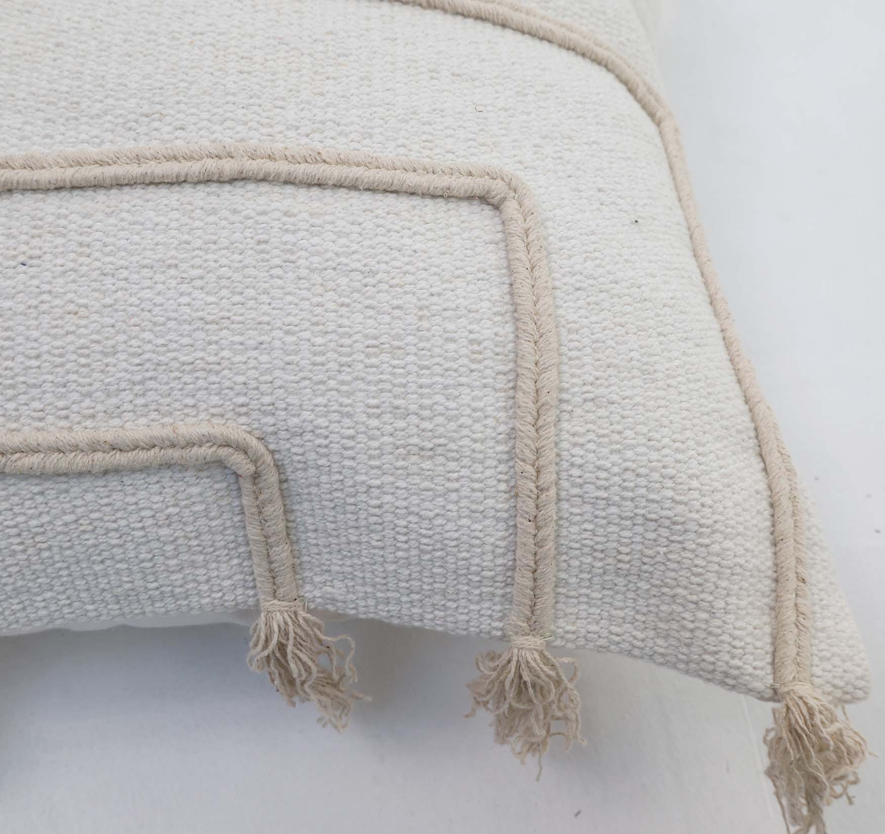 The Cotton Cushion Natural & White Color - CS 299 (45x45cm) by Ramsha Home features elegant beige raised geometric lines, corner tassels, and is perfect for stylish home décor.