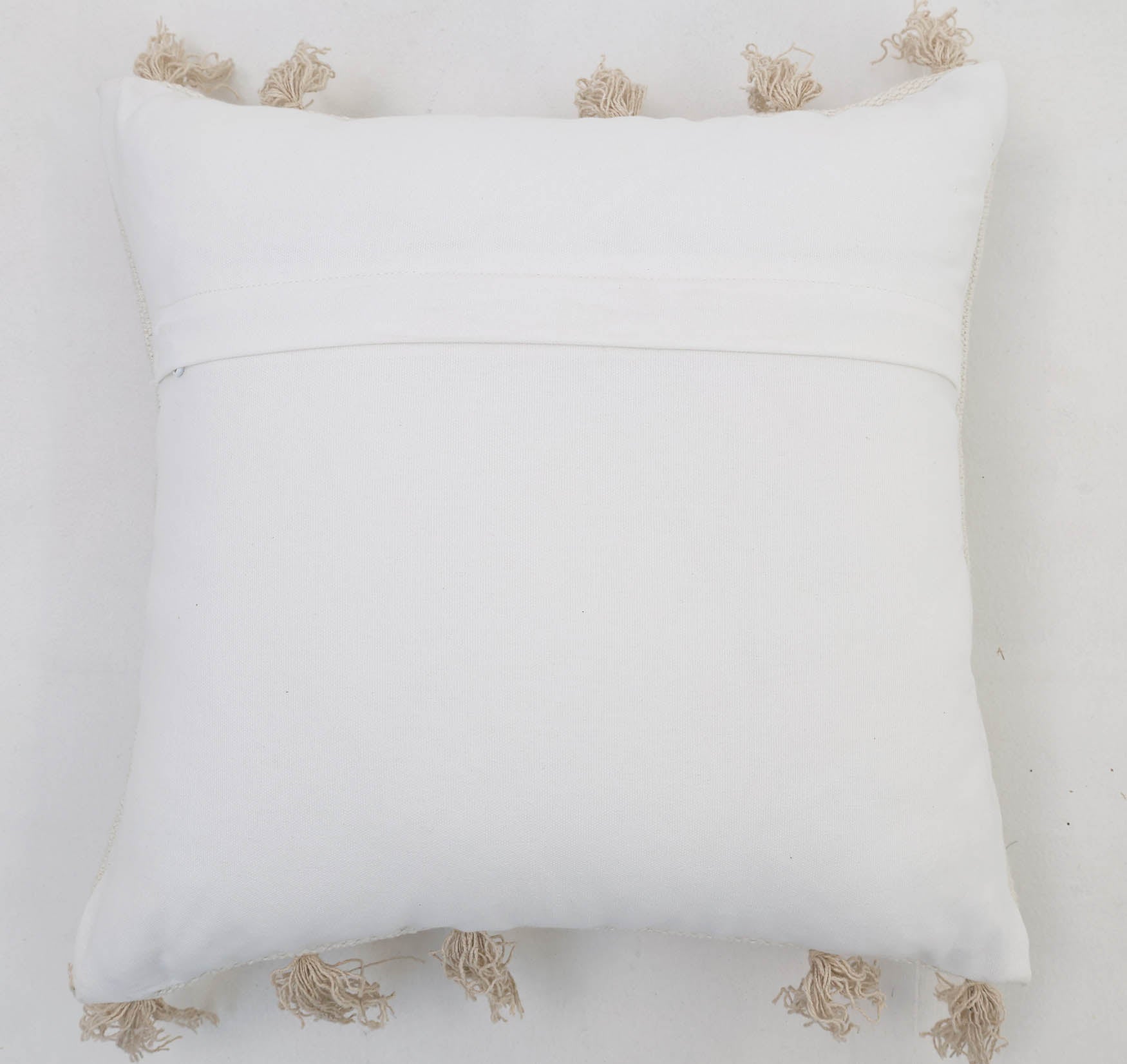 The Ramsha Home Cotton Cushion Natural & White Color - CS 299 (45x45cm) features beige tassels on each edge, a visible back seam, and a simple design—perfect as an elegant home decor accent.