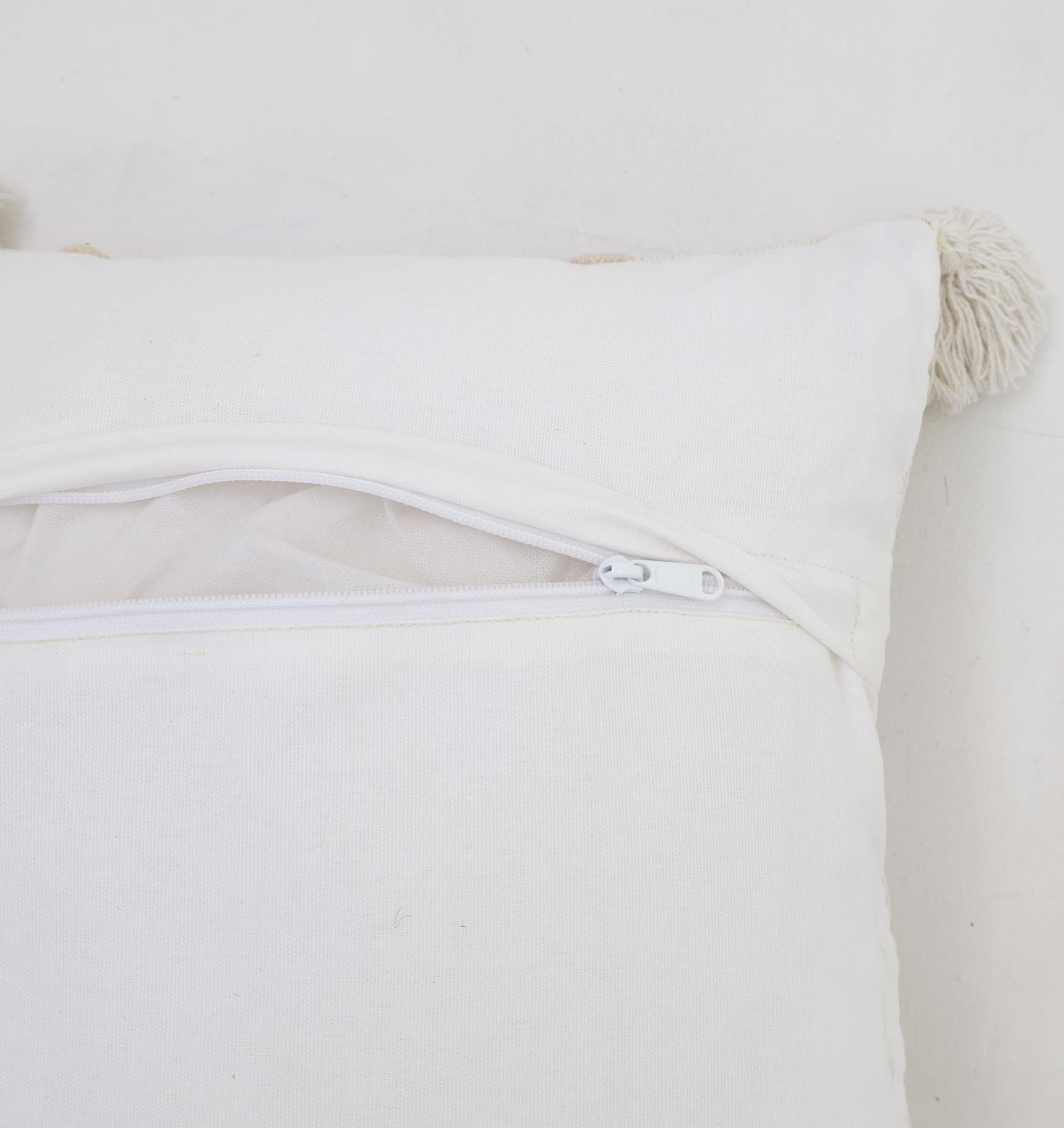 A close-up of the Ramsha Home Decor Tassel Cushion (Natural & White, 45x45 cm) shows a partially open zipper with mesh lining. This home furnishing features a charming tassel at one corner and rests on a white surface.