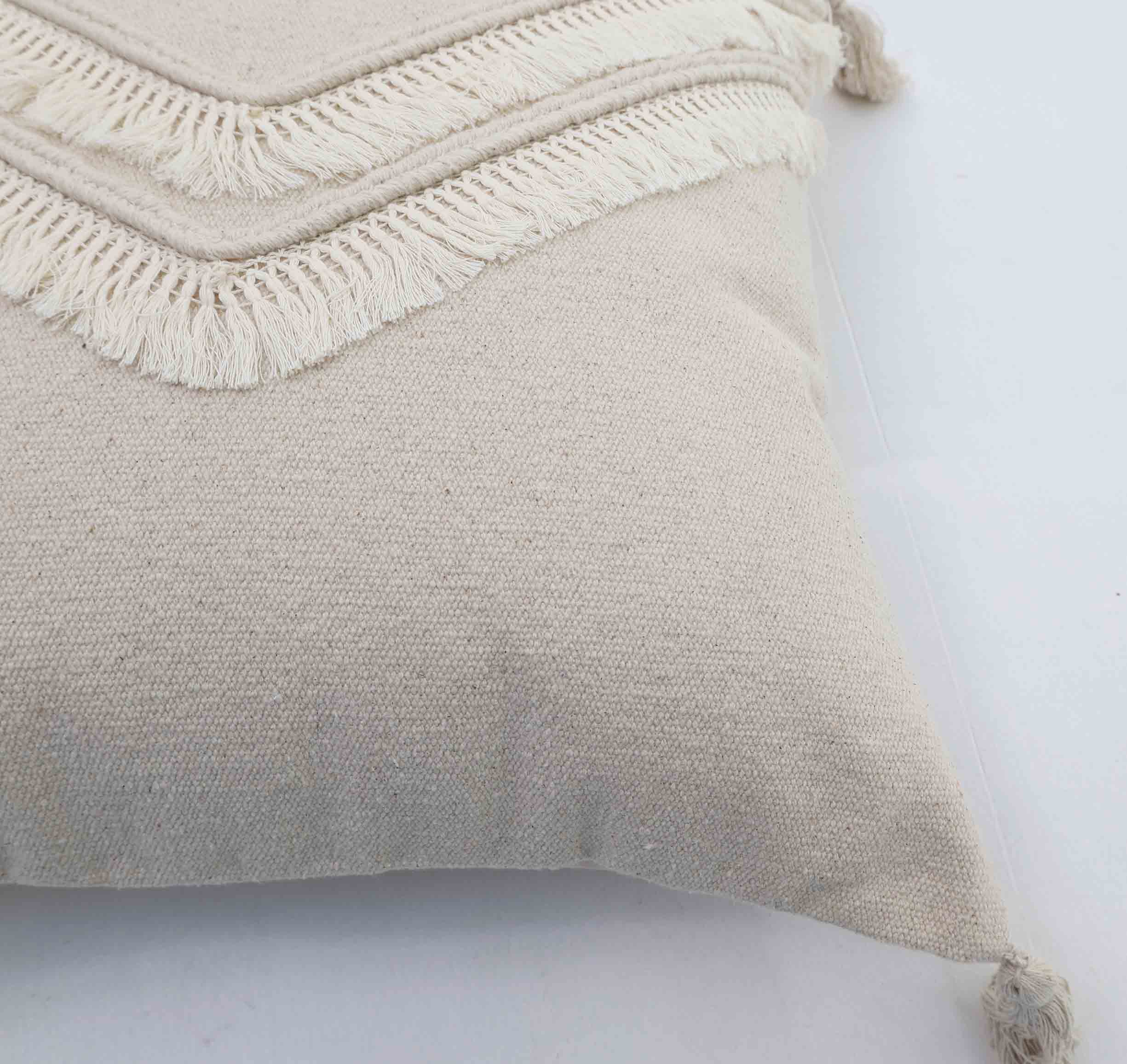 A close-up of the Ramsha Home Decor Tassel Cushion Natural Color - CS 305 (45x45cm), showing its textured fabric and layered fringed tassels at the edges—a stylish accent from a luxury UAE brand.