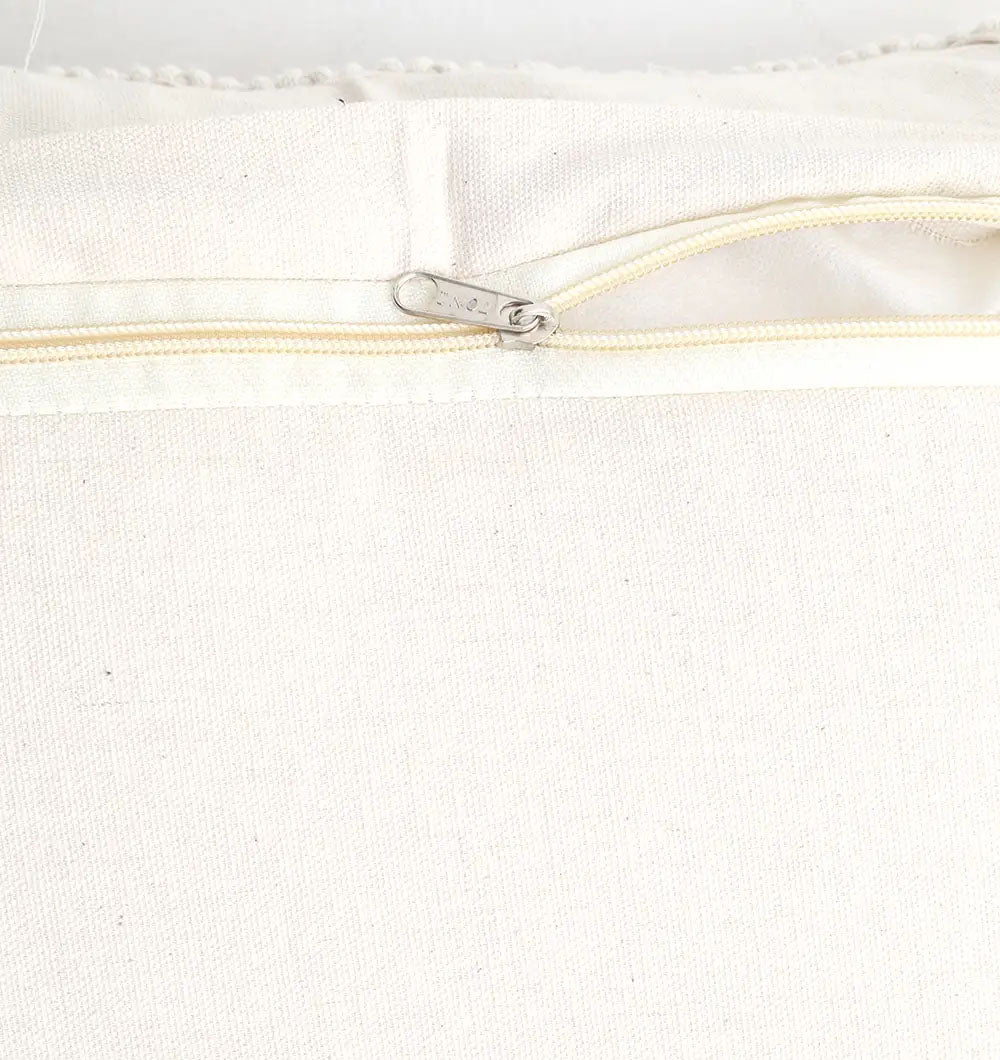 Close-up of the Ramsha Home Natural White Macrame Sofa Cushion (CS 309), highlighting a partially open light zipper with detailed stitching on the handcrafted fabric by the luxury UAE furnishings brand.