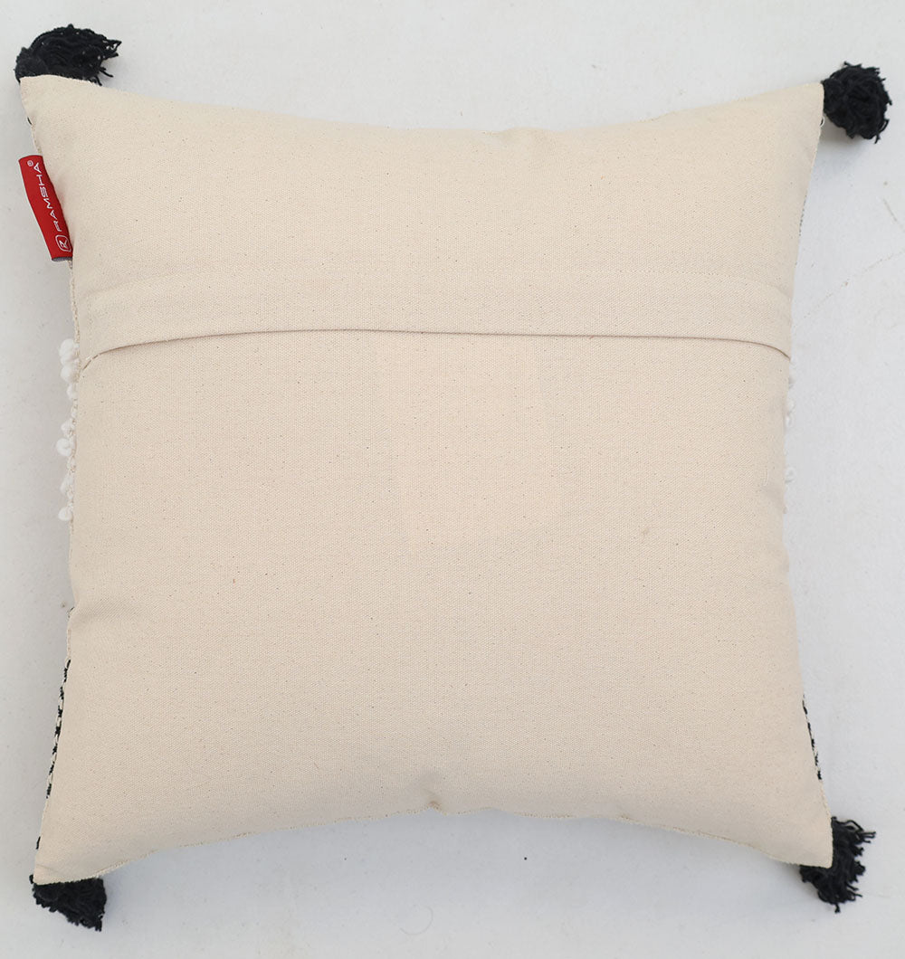The Multi Color Home Decor Cushion - CS 314 C by Ramsha Home features a square beige cotton design with tassels on each corner, a visible back seam, and a small red tag, displayed on a white surface.