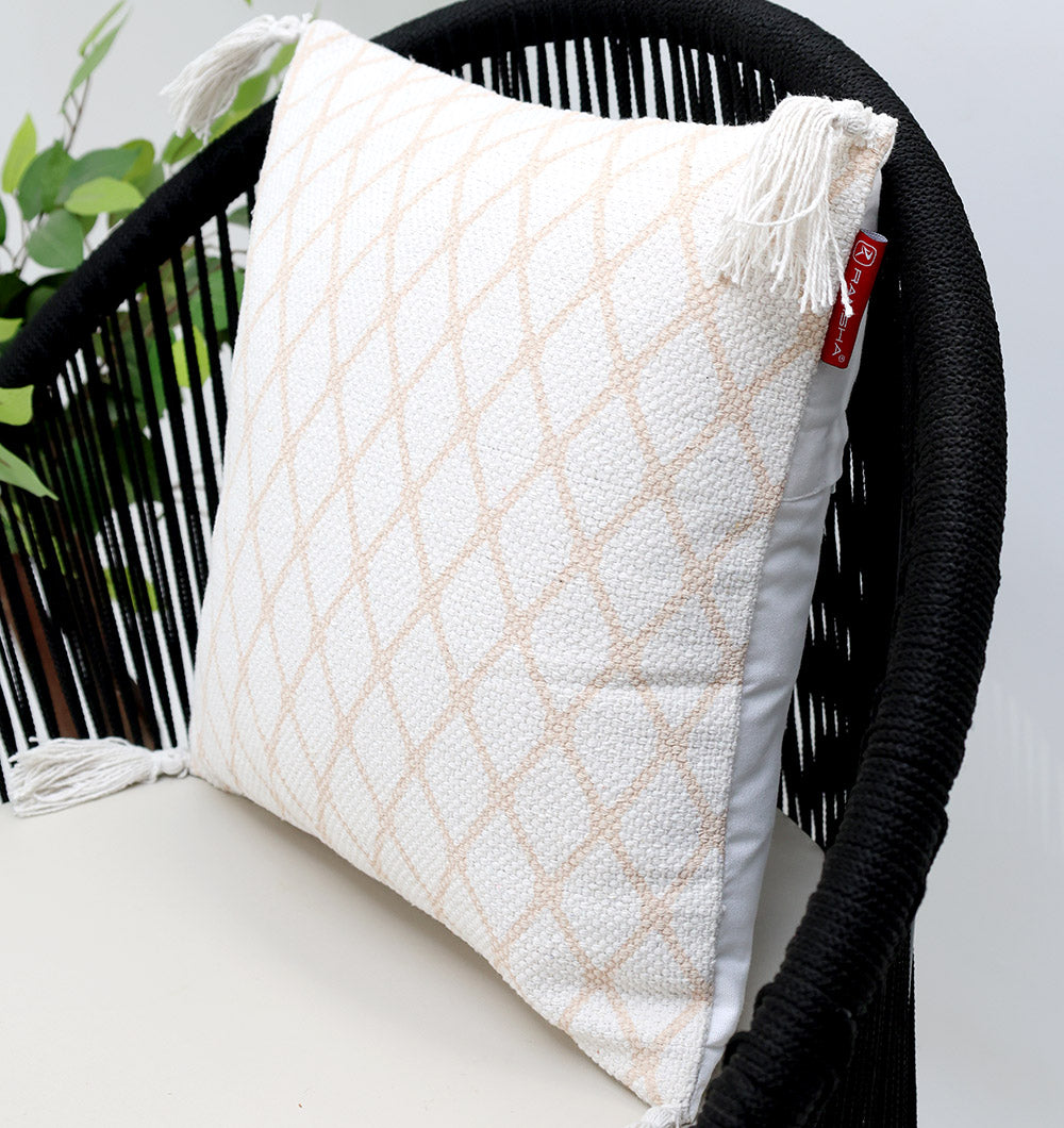 The White and Peach Color Cushion 45x45 cm CS 316 by Ramsha Home adds style to a black woven chair, with green plant leaves in the background for a fresh look.