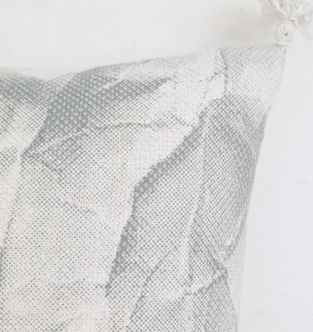 Close-up of the Ramsha Home White and Grey Printed Cotton Cushion 45x45 cm (CS 321), showcasing its abstract pattern and decorative tassel for an elegant touch.