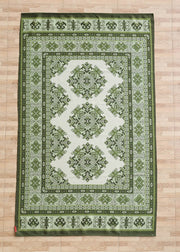 A rectangular green and white RAMSHA HOME Contemporary Tribal Digital Print Rug (145x240 cm, DD-053) with intricate geometric and floral motifs lies on a light wood floor, its design echoing symmetrical patterns within multiple decorative borders.