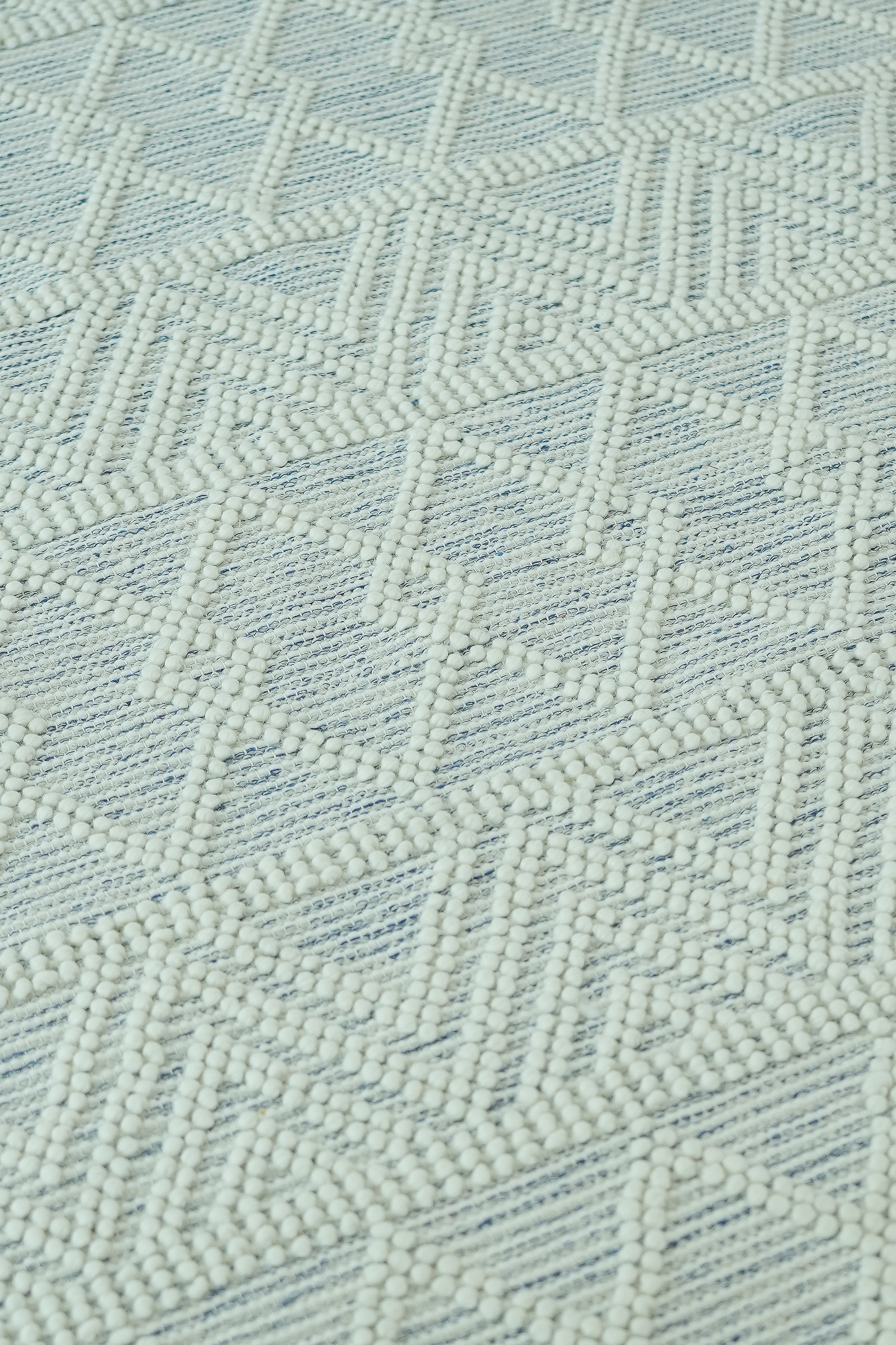Close-up of the RAMSHA HOME Handmade Woven Rug SRN-021, featuring a natural and white color palette with raised dots forming a geometric zigzag and diamond pattern.
