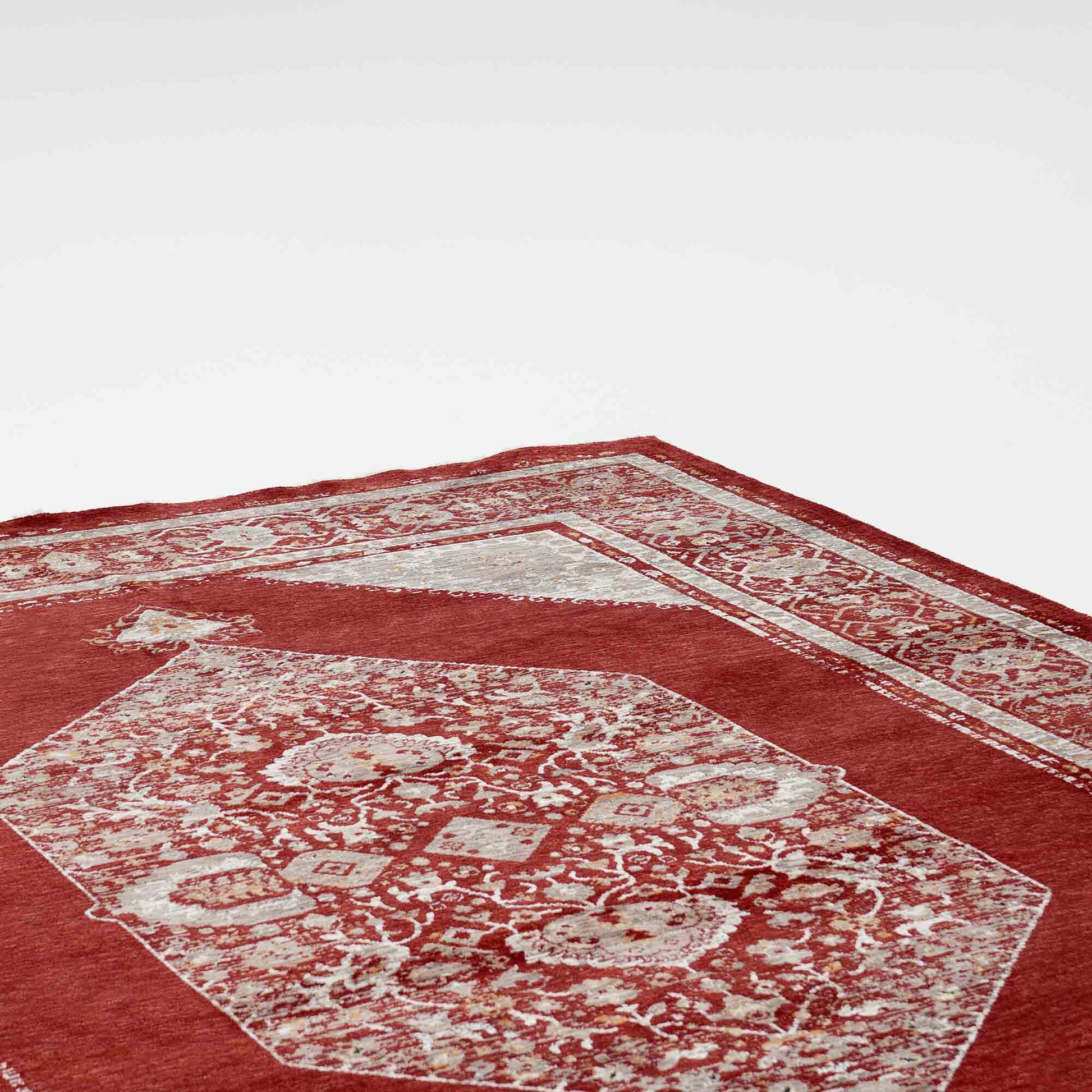 A close-up of the RAMSHA HOME Luxurious Texture Turkey Multi Color Machine Made Rug - K643C, featuring ornate white designs and a detailed border, displayed at an angle on a plain white background.