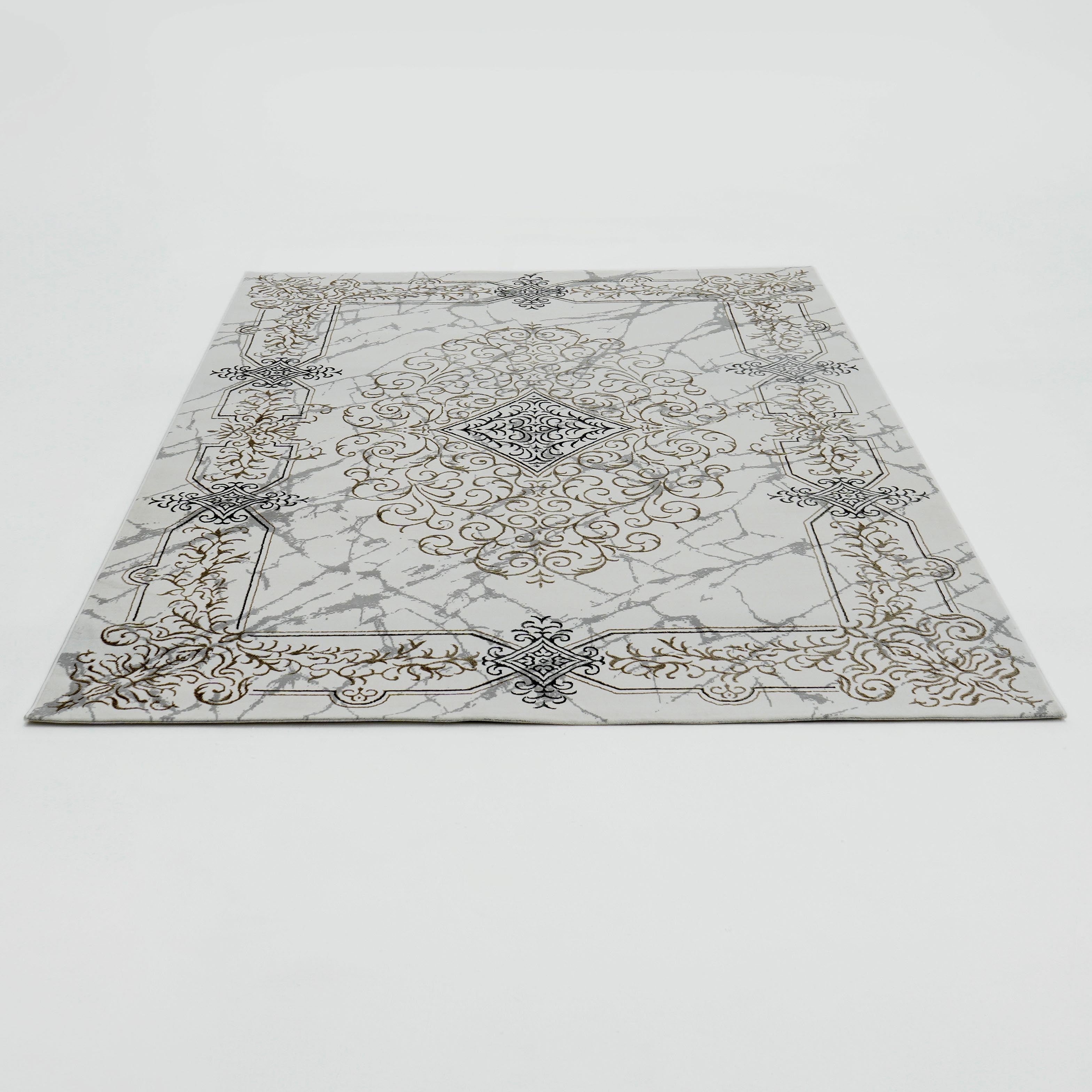 The RAMSHA HOME Beige Color Polyester NK33C Area Rug displays an ornate, symmetrical gold and dark gray pattern with scrolling details and a central medallion on a white background, laid flat on a white surface.