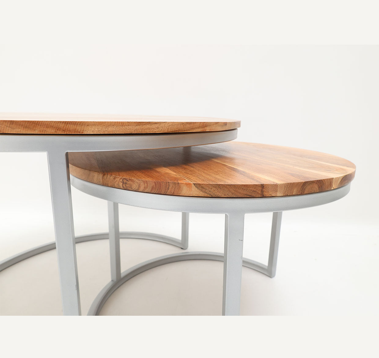 The RAMSHA HOME Modern Nesting Coffee Table Set GH-001 features two round tables with wooden tops and white metal frames, partially stacked on a plain white background. Their minimalist design and clean lines suit any modern space.