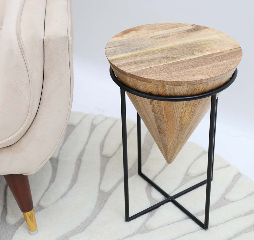 The RAMSHA HOME Modern Cone Accent Side Table – Solid Wood & Iron Base GH-002, featuring a conical wood base and round top with a black iron frame, stands by a light sofa on a patterned rug.