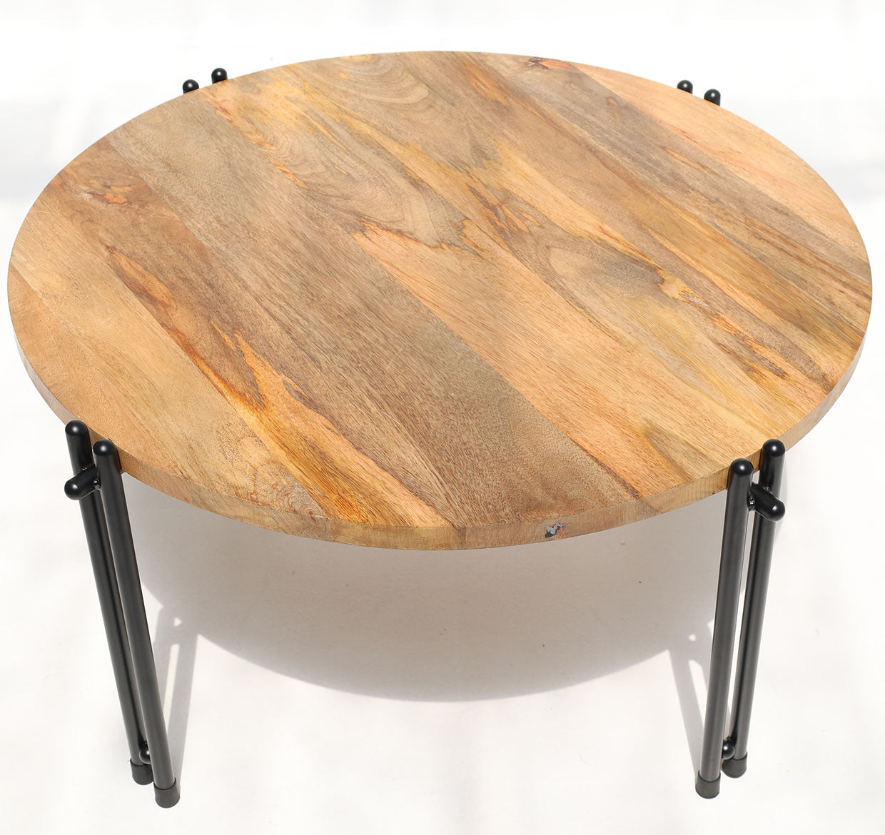 The RAMSHA HOME Modern Round Coffee Table – Solid Wood Top with Black Iron Legs GH-067 is displayed on a white surface, highlighting its natural wood finish and sturdy black legs amid subtle light and shadow.