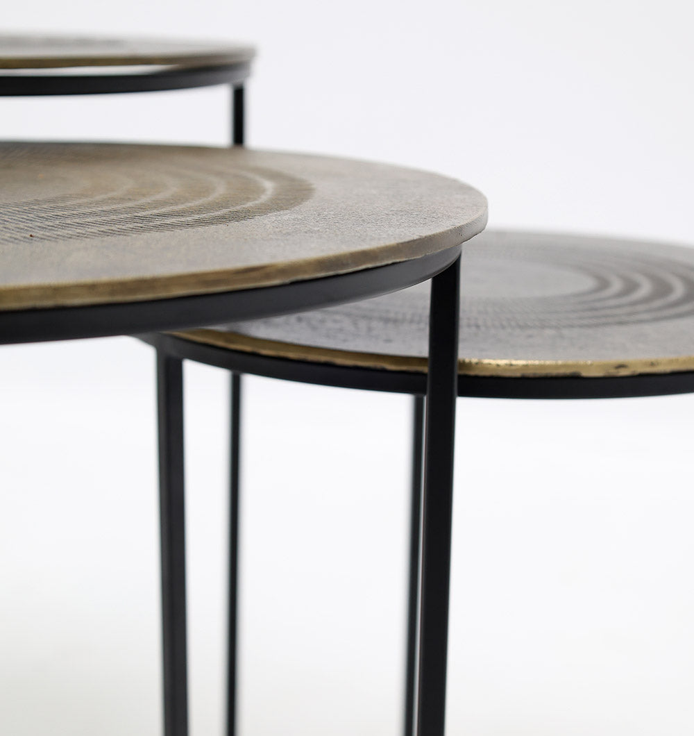 Close-up of RAMSHA HOME Set of 3 Modern Nesting Side Tables (GH-070), featuring antique brass-finished tops and slender black iron bases, displayed against a plain white background.