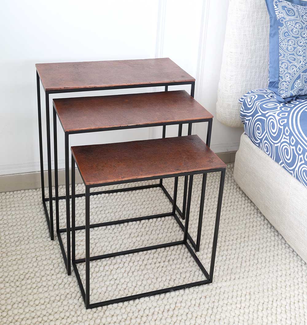 RAMSHA HOME’s Modern Three-Tier Side Tables (GH-111-B) with black iron bases and black powder/copper finish are set on a light textured rug beside a blue and white patterned couch.