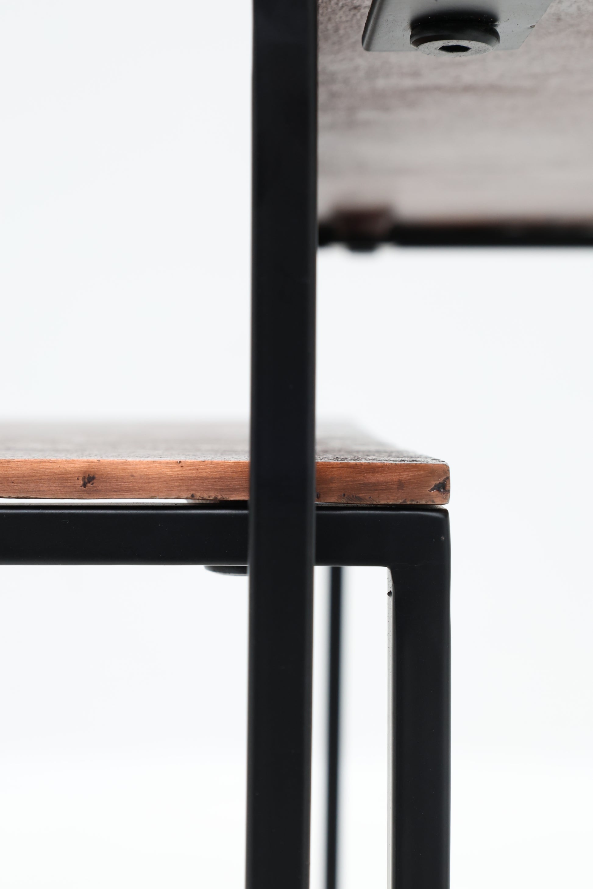 Close-up of the edge of a light wood-look tabletop and matching shelf from the RAMSHA HOME Modern Three-Tier Side Tables – Black Powder/Copper Finish with Black Iron Base GH-111-B, set against a plain white background.