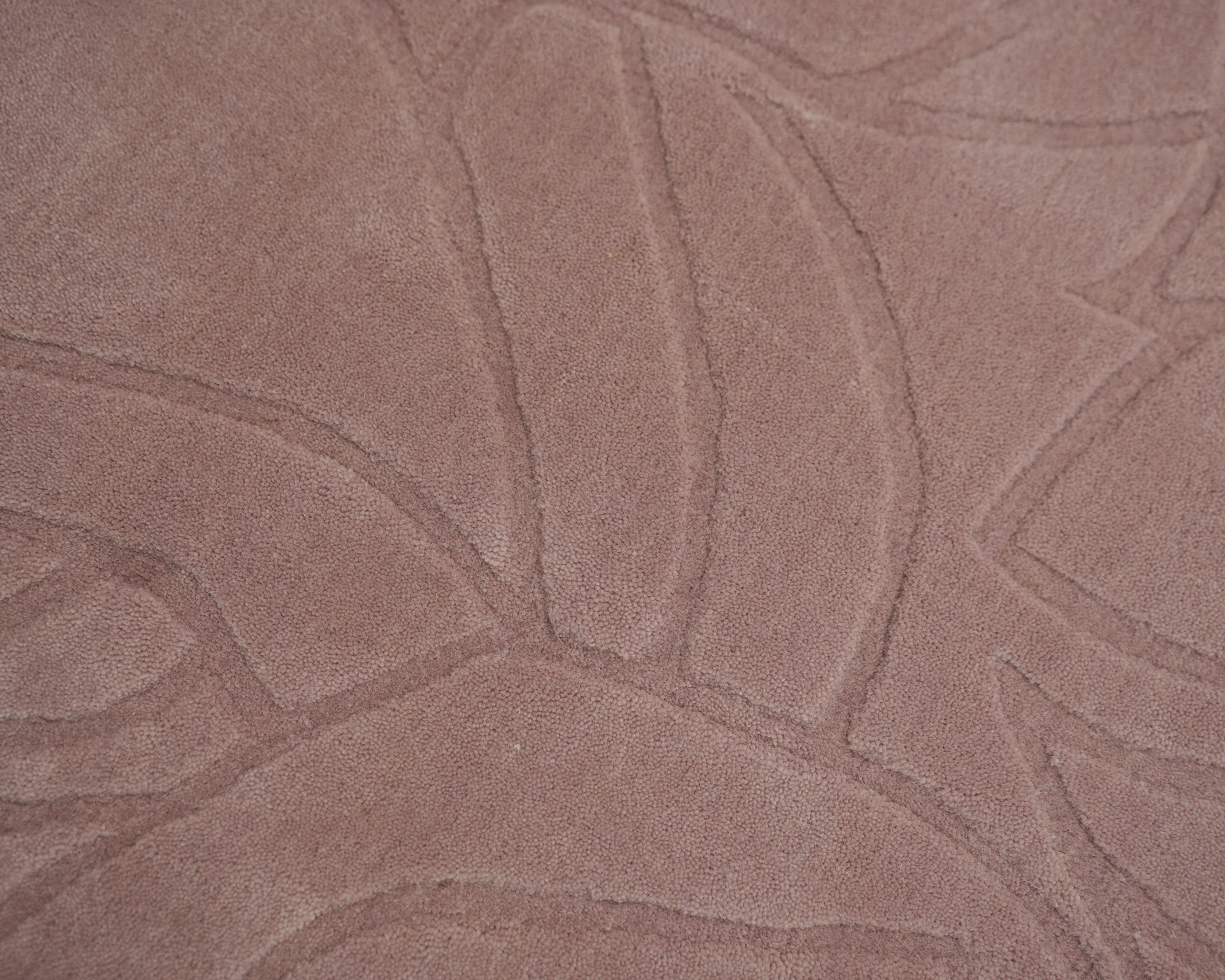 Close-up of the RAMSHA HOME Rectangle Handmade Pink Color Area Rug (LKH-029), featuring a textured dusty pink surface and raised abstract curved lines in a carved floral or leaf-like pattern.