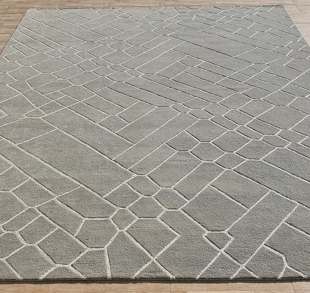 The Luxurious Handmade Rug - HTP 12 (300x400cm) by RAMSHA HOME features a light grey abstract geometric pattern with raised lines, adding modern texture and warmth to wooden floors.