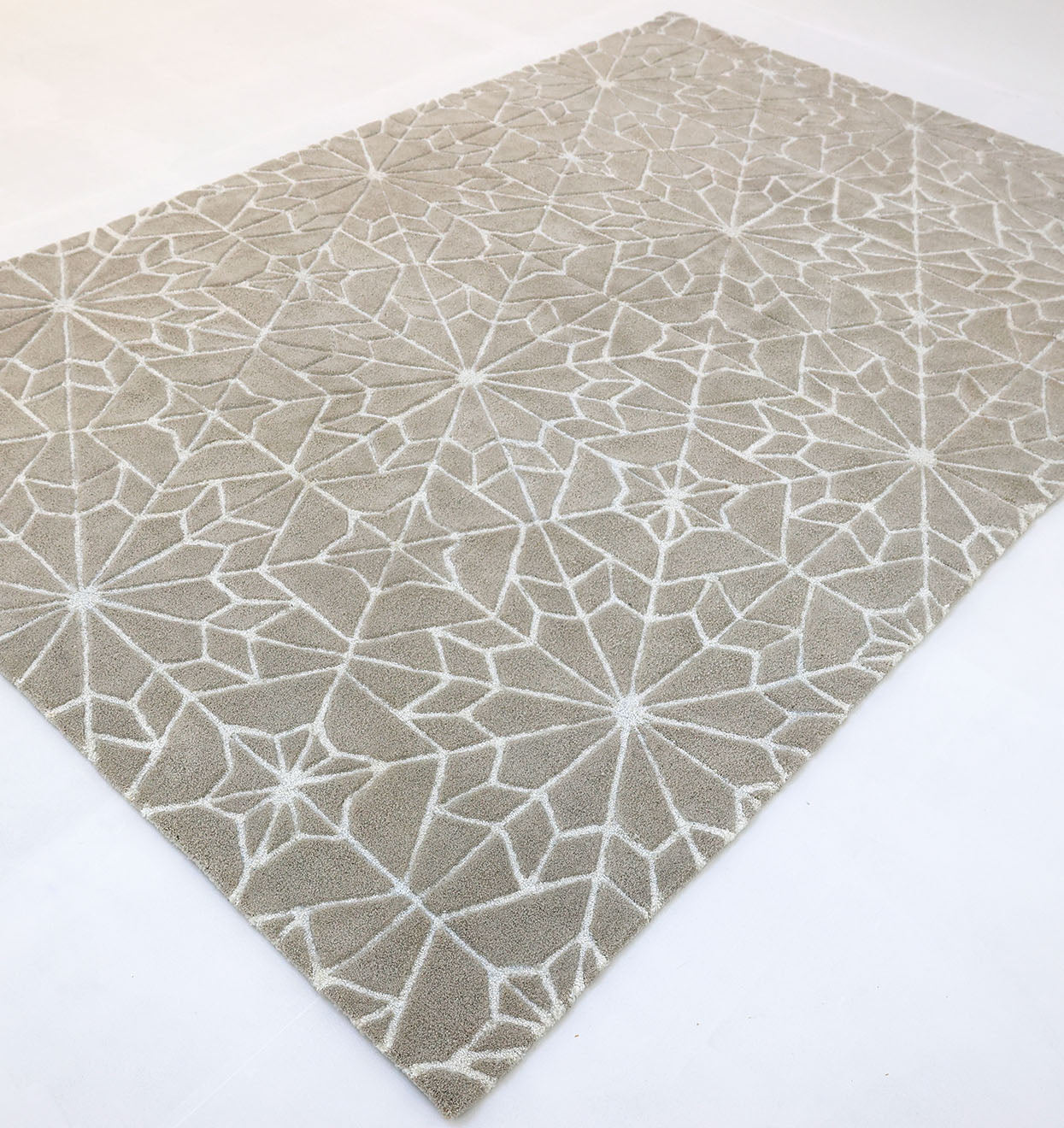 The RAMSHA HOME Modern Rectangle Area Rug Multi Color HTP-18 features interconnected white lines and star shapes on beige, shown on a plain light surface.
