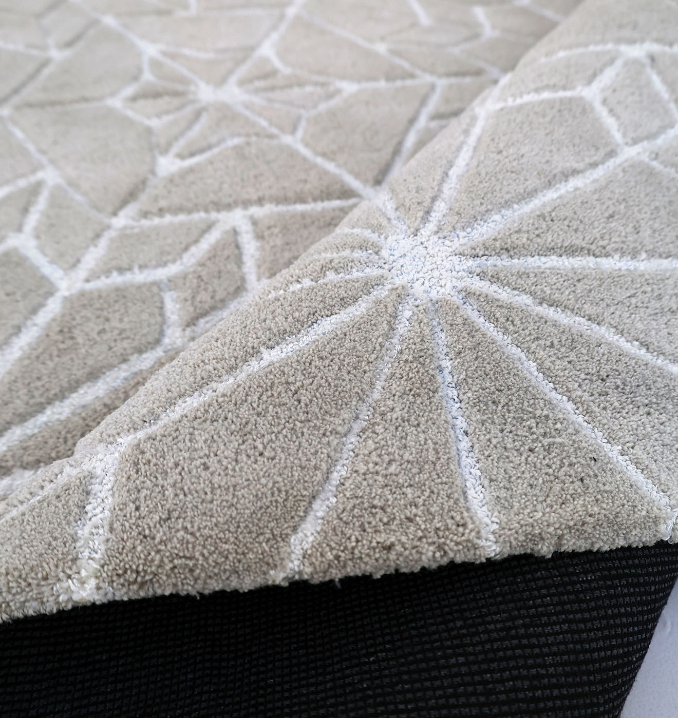 Close-up of the RAMSHA HOME Modern Rectangle Area Rug Multi Color HTP-18, featuring a beige hand tufted design with raised geometric patterns, white lines for texture, and a black non-slip backing visible under one corner.