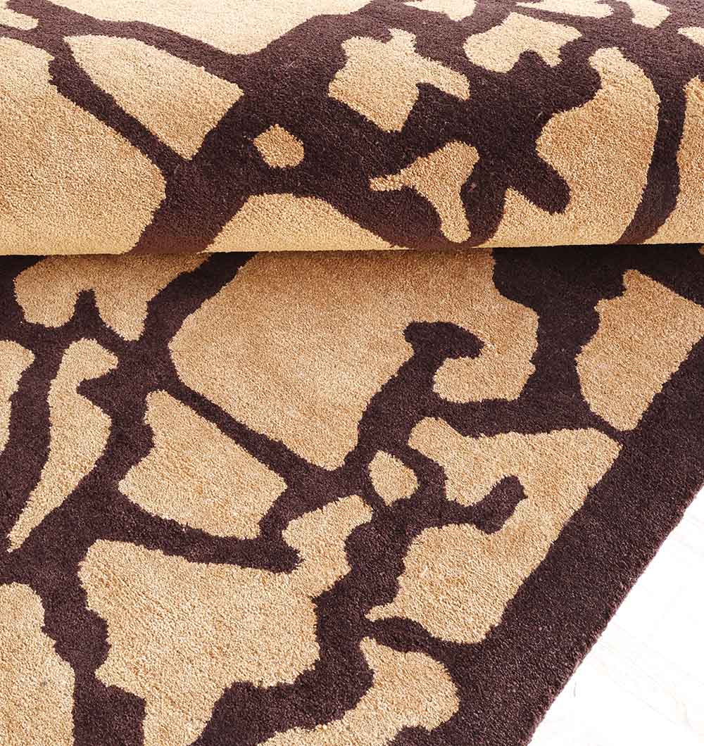 A close-up of the RAMSHA HOME Multi Handmade Area Rug - HTP 21 (200x300cm) in beige with a bold dark brown pattern, hand tufted and slightly folded to showcase its texture and thickness.