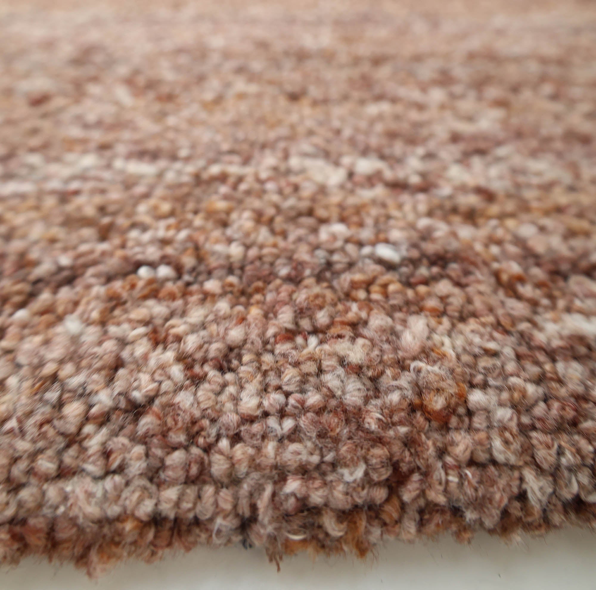 Close-up of the RAMSHA HOME Handmade Wool Rug – Textured Beige Area Rug (HTP 26), showing its tightly woven loops in beige and tan shades, with a focus on the dense, soft fibers and detailed texture along the surface and edge.