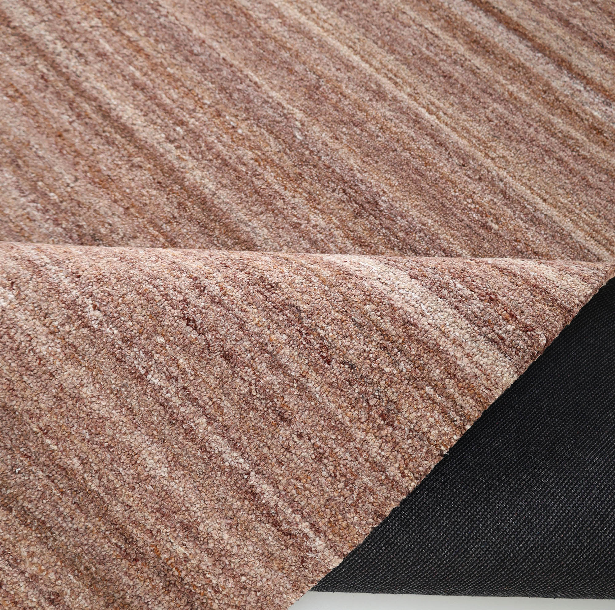 A close-up of RAMSHA HOME's Handmade Wool Rug – Textured Beige Area Rug (HTP 26), featuring subtle stripes, with one corner flipped to display the black non-slip backing underneath.