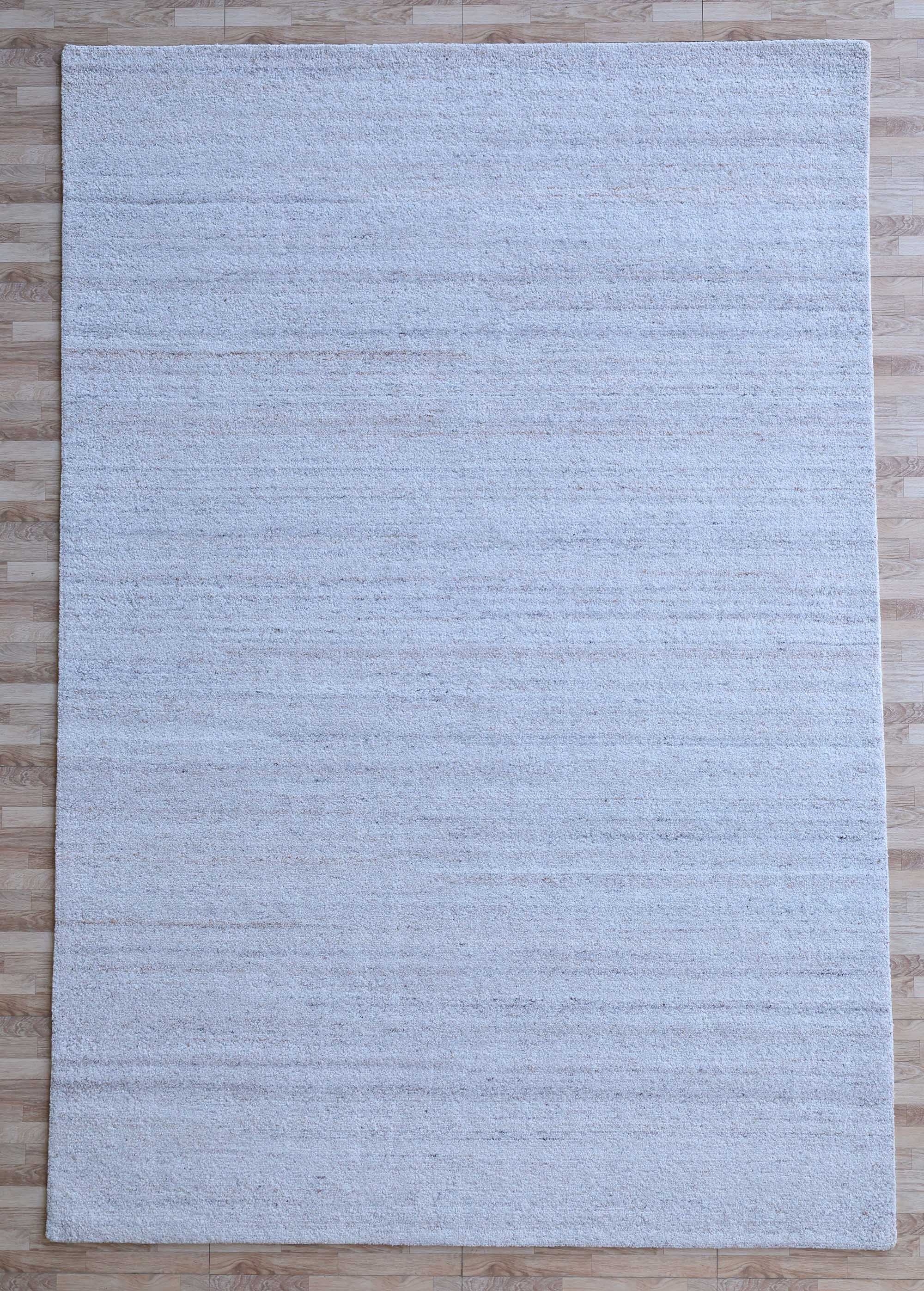 The RAMSHA HOME Natural Ivory Handmade Wool Rug – Modern Luxury Area Rug HTP 28, a large rectangular piece with subtle horizontal patterns and minimalist design, is shown on a light wood floor from above.