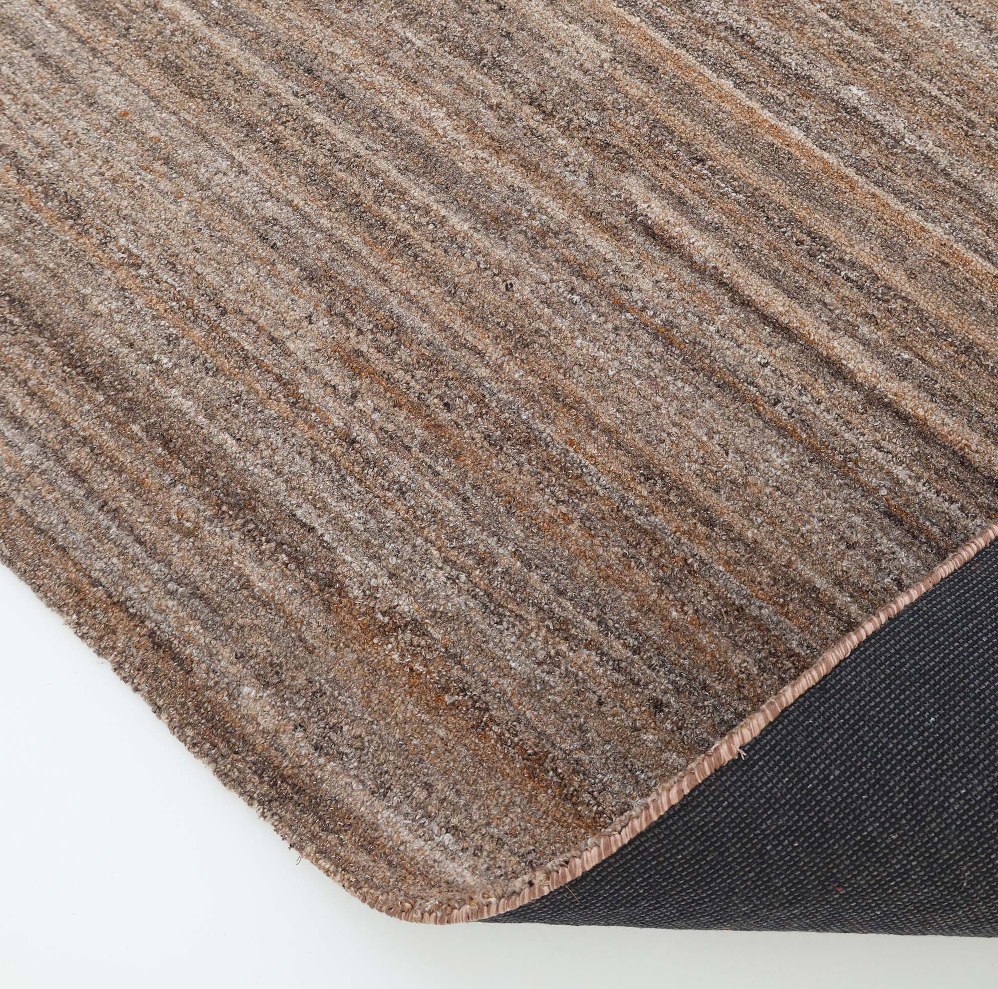 Close-up of the RAMSHA HOME Handmade Earth Strata Wool Rug HTP 29, showcasing its brown stripes and textured surface. A corner is flipped to reveal the black, non-slip backing against a white background.