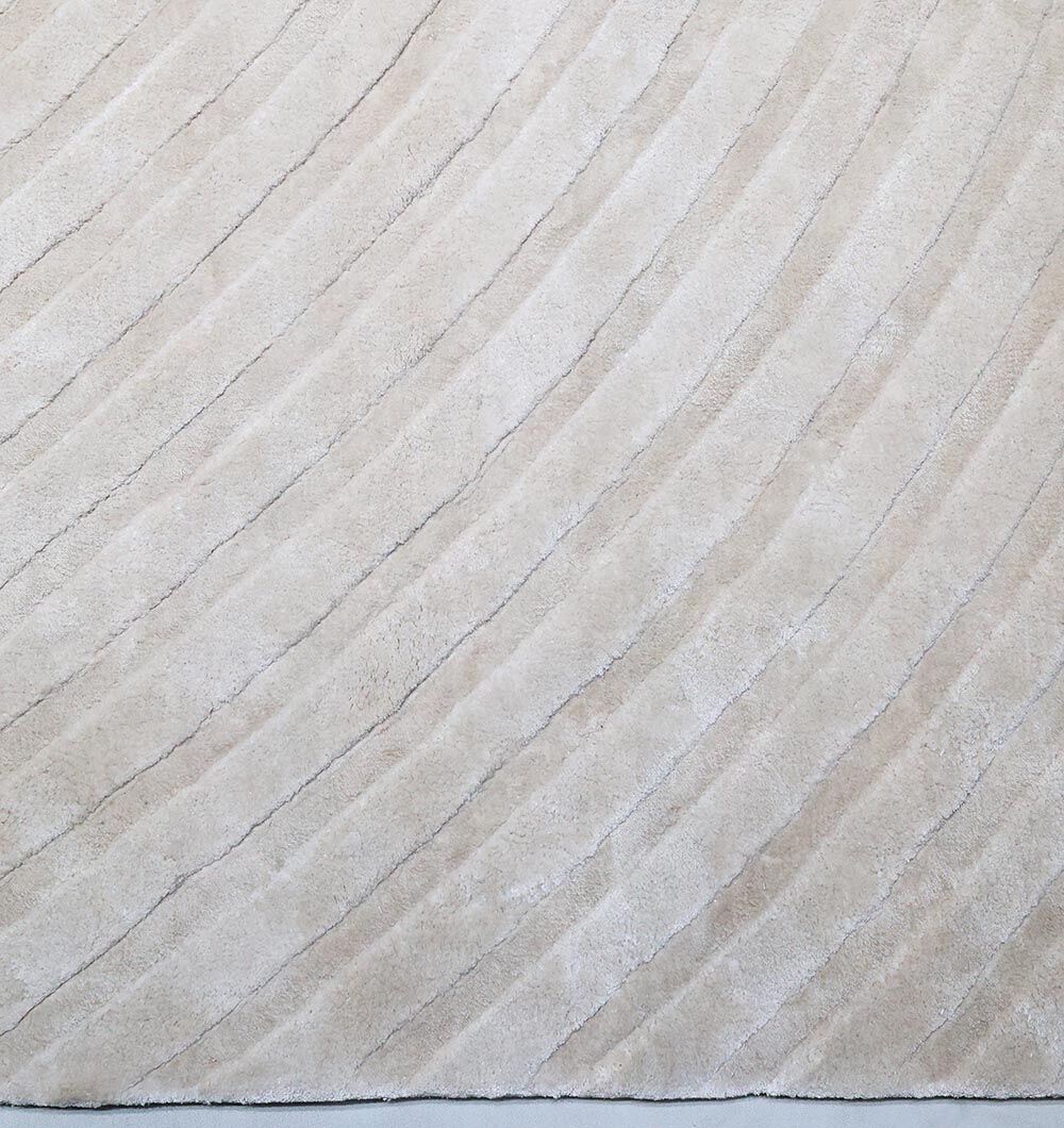 The Off White Handmade Rug - HTV 14 by RAMSHA HOME features a beige textured surface with subtle curved lines, creating a soft, elegant look—an ideal neutral area rug for any space.