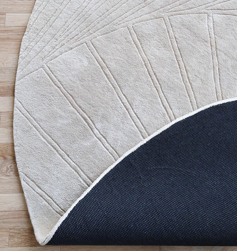 The Home Decor Handmade Rug - HTV 16 (200cm) by RAMSHA HOME, in beige with a geometric textured design, is handtufted from wool and shown partially lifted to display its dark non-slip backing over a light wooden floor.