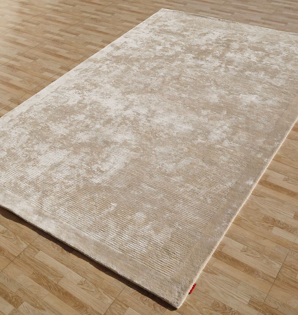 The RAMSHA HOME Beige Color Handmade Rug - HTV 18 (200X300 cm), featuring a subtle textured pattern, is placed on a light, natural-finish wooden floor.