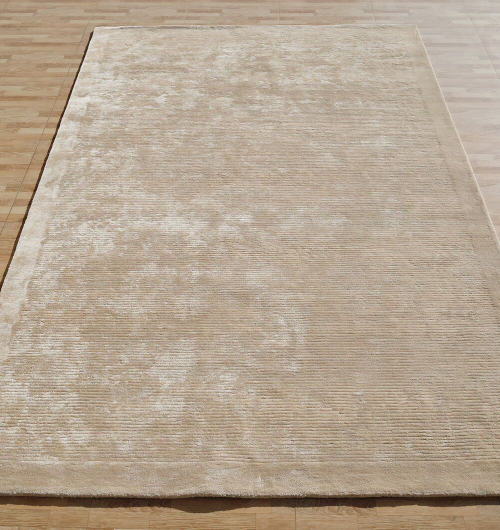 The RAMSHA HOME Beige Color Handmade Rug - HTV 18 (200x300 cm), featuring a soft velvety finish and subtle textured pattern, adds a touch of simple elegance to the wooden floor with its neutral rectangular design.