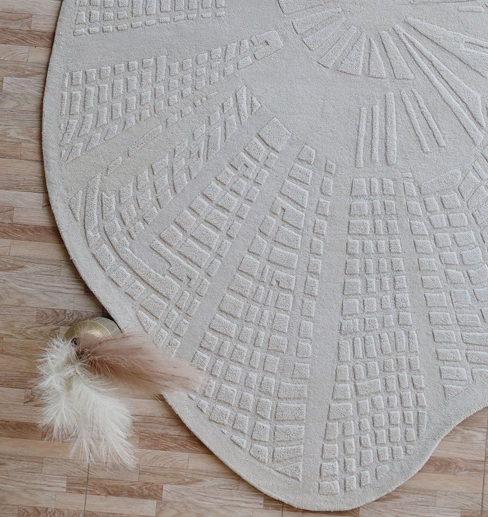 The RAMSHA HOME Handmade Area Rug - HTW 112 (200x300 cm) with ivory-beige geometric patterns is placed on a light wood floor. A gold bowl in the corner displays beige and white pampas grass.