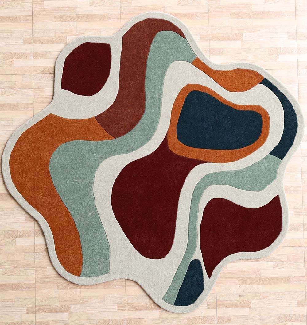 The RAMSHA HOME Handmade Shaped Abstract Round Rug - HTW 121 (200cm) features wavy, color block sections in maroon, rust, teal, light green, and beige wool and is shown on a light wood floor.