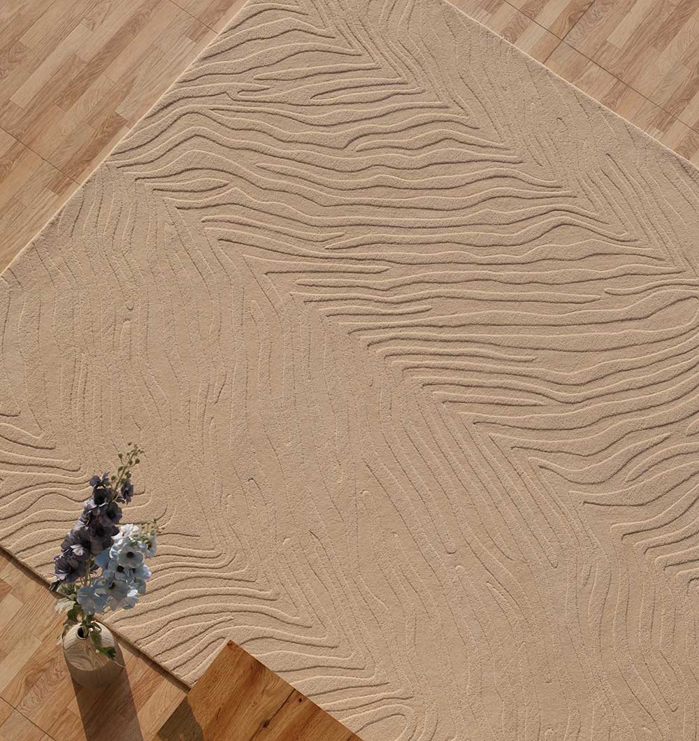 The RAMSHA HOME Rectangle Shape Beige Color Handmade Area Rug - HTW 133 (200x300 cm) with a raised wavy and zigzag texture lies on a light wood floor. A clear vase of purple and white flowers sits on the lower left step.