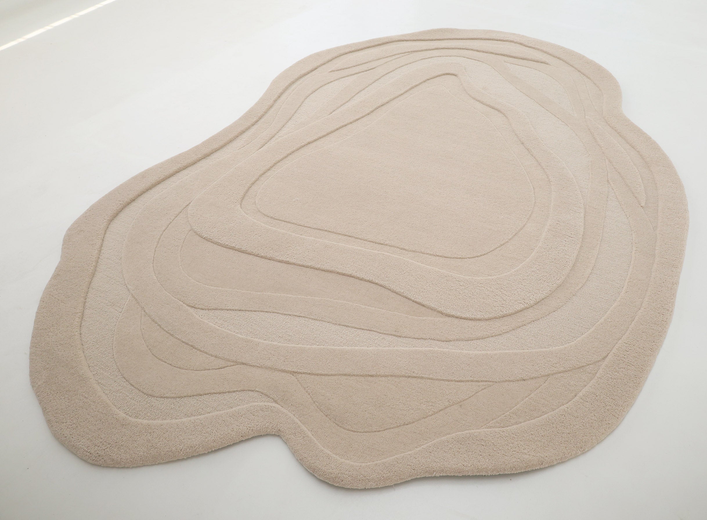 The RAMSHA HOME Contemporary Flow Area Handmade Rug HTW-146 features layered wavy contours, adding visual depth and style to any light-colored floor.