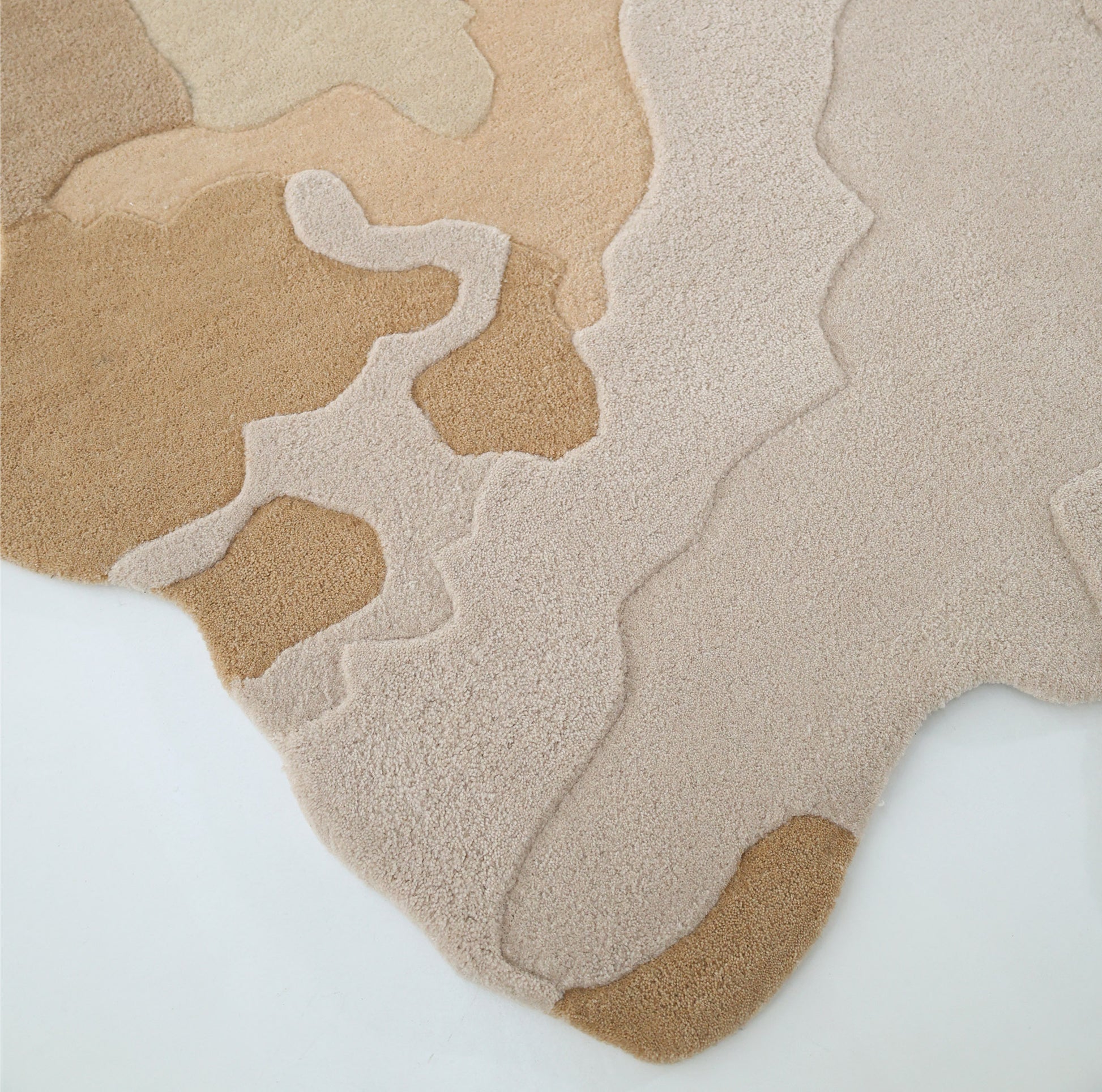 The RAMSHA HOME Contemporary Flow Area Handmade Rug HTWV-153 features organic, abstract ovals in beige, tan, and light brown on a crisp white background, evoking natural land formations with an artistic border.