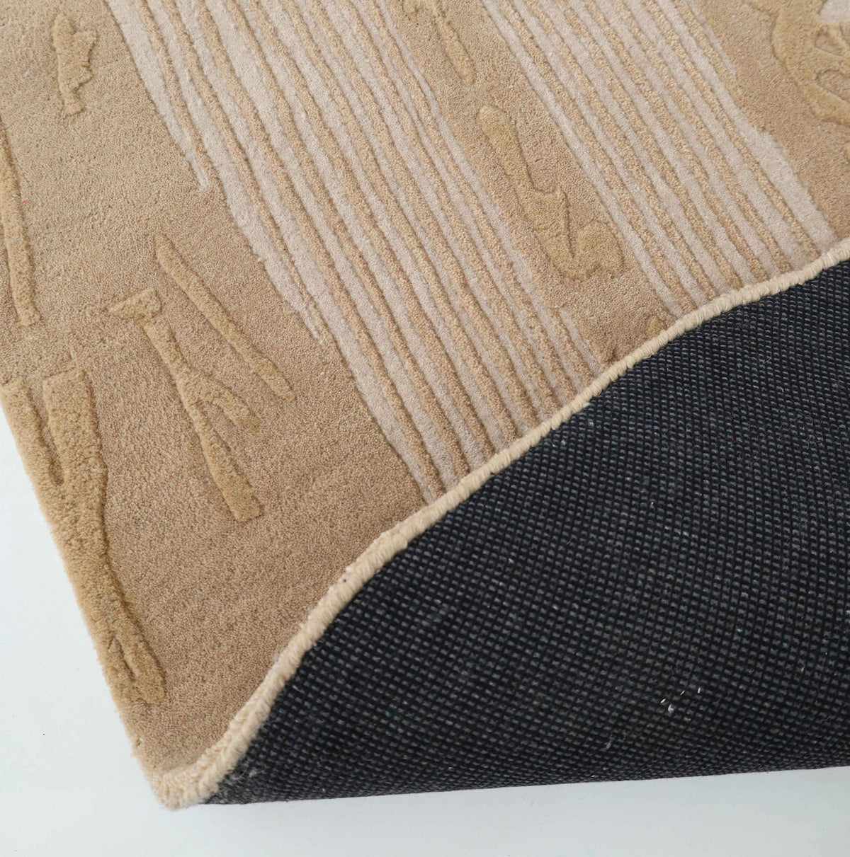 The Abstract Beige Rug – Neutral Textured Modern Area Rug with Organic Pattern (HTW 156) by RAMSHA HOME is shown with a raised, textured design in beige. One corner of the rug is flipped over, displaying its dark, woven backing against a white surface.
