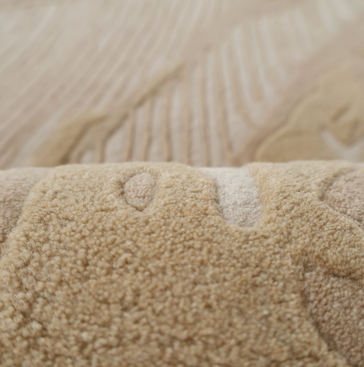 Close-up of the RAMSHA HOME Abstract Beige Rug – Neutral Textured Modern Area Rug with Organic Pattern (HTW 156), highlighting its raised, wavy design and fine beige and tan fibers. The soft surface is in focus against a blurred background, showcasing this elegant rug’s ability to add subtle warmth and modern sophistication to any space.