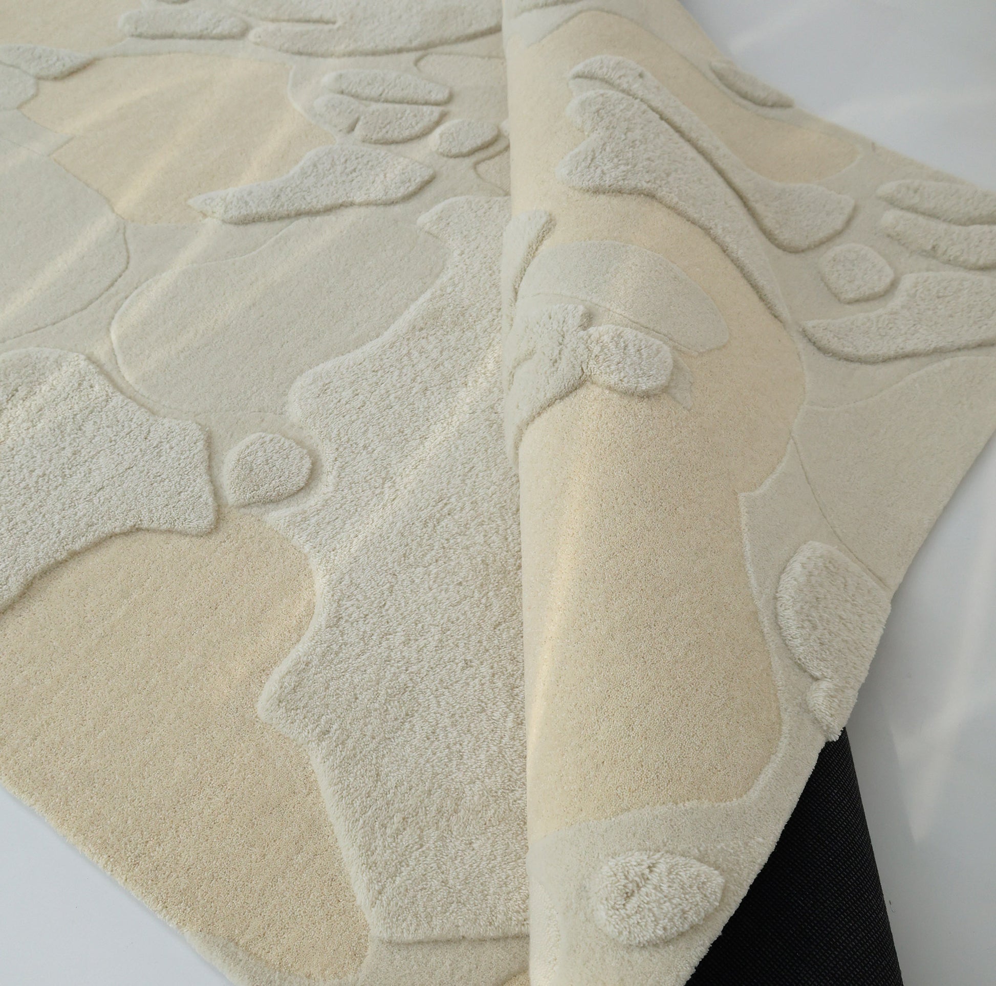 A close-up of the RAMSHA HOME Creative Multi Color Wool & Cotton Handmade Rug - HTW 69 (200x300cm) displays its raised patterns and dark backing, highlighting the unique design and quality craftsmanship.