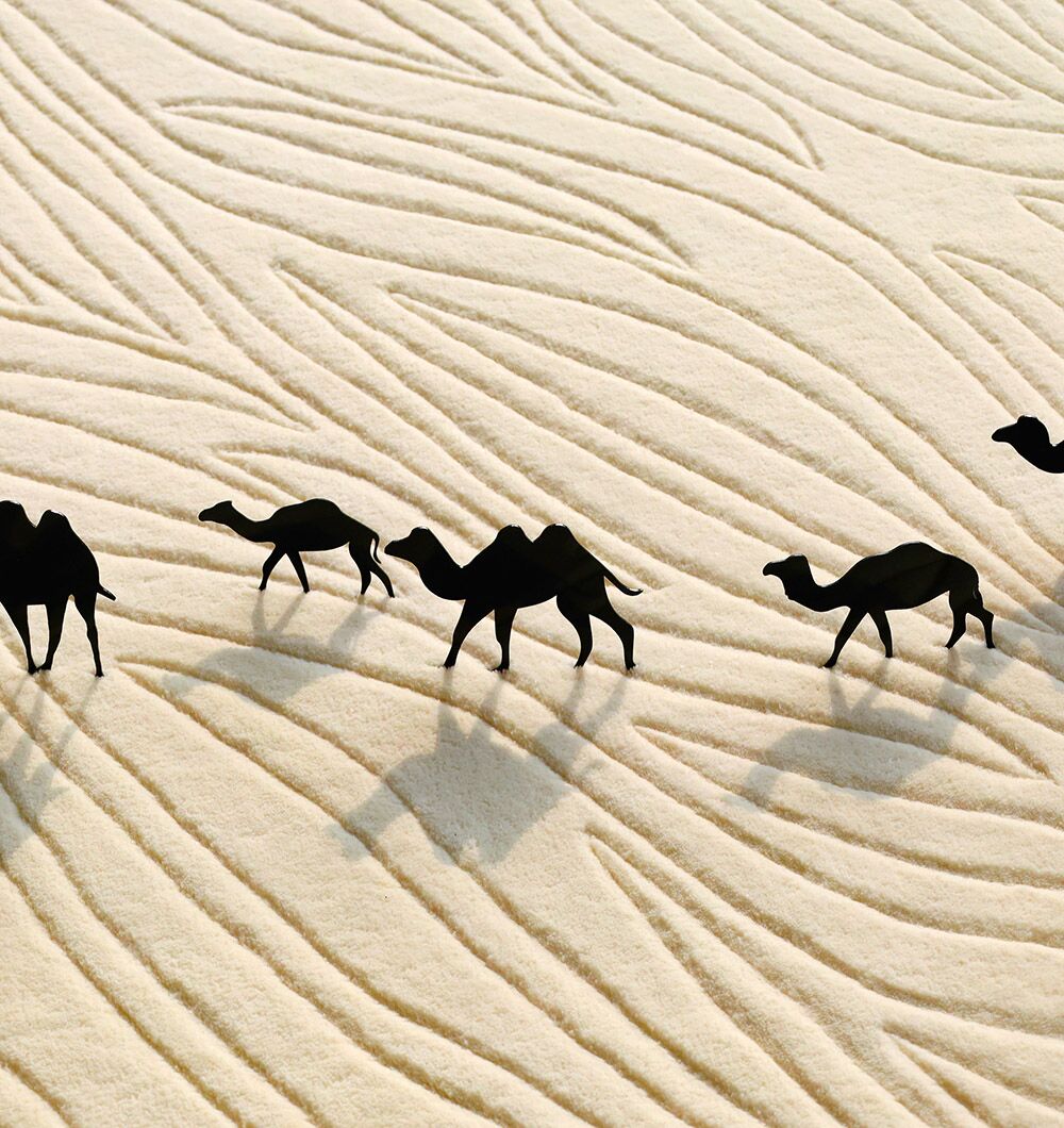 The Natural White Color Handmade Area Rug - HTW-89 (300X400 CM) by RAMSHA HOME features light, wavy patterns reminiscent of camels walking across sand dunes, evoking a minimalist and textured look.