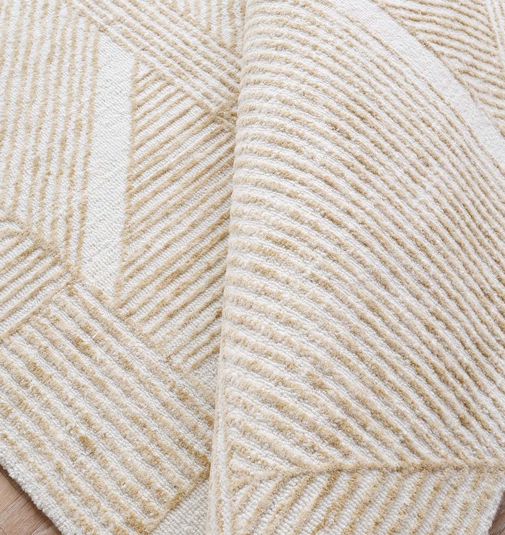 A close-up of the RAMSHA HOME Multi Color Handmade Area Rug - HTW-91 (200x300 CM), displaying its soft texture, geometric patterns, beige and cream tones, and raised ribbed lines for a thick, hand-tufted look.