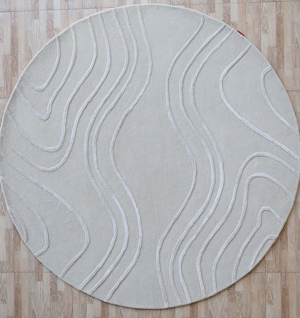 The Multi Color Handmade Area Rug - HTWV-133 by RAMSHA HOME features a round, hand-tufted wool design with subtle wavy textured lines in light beige, shown on a light wood floor.