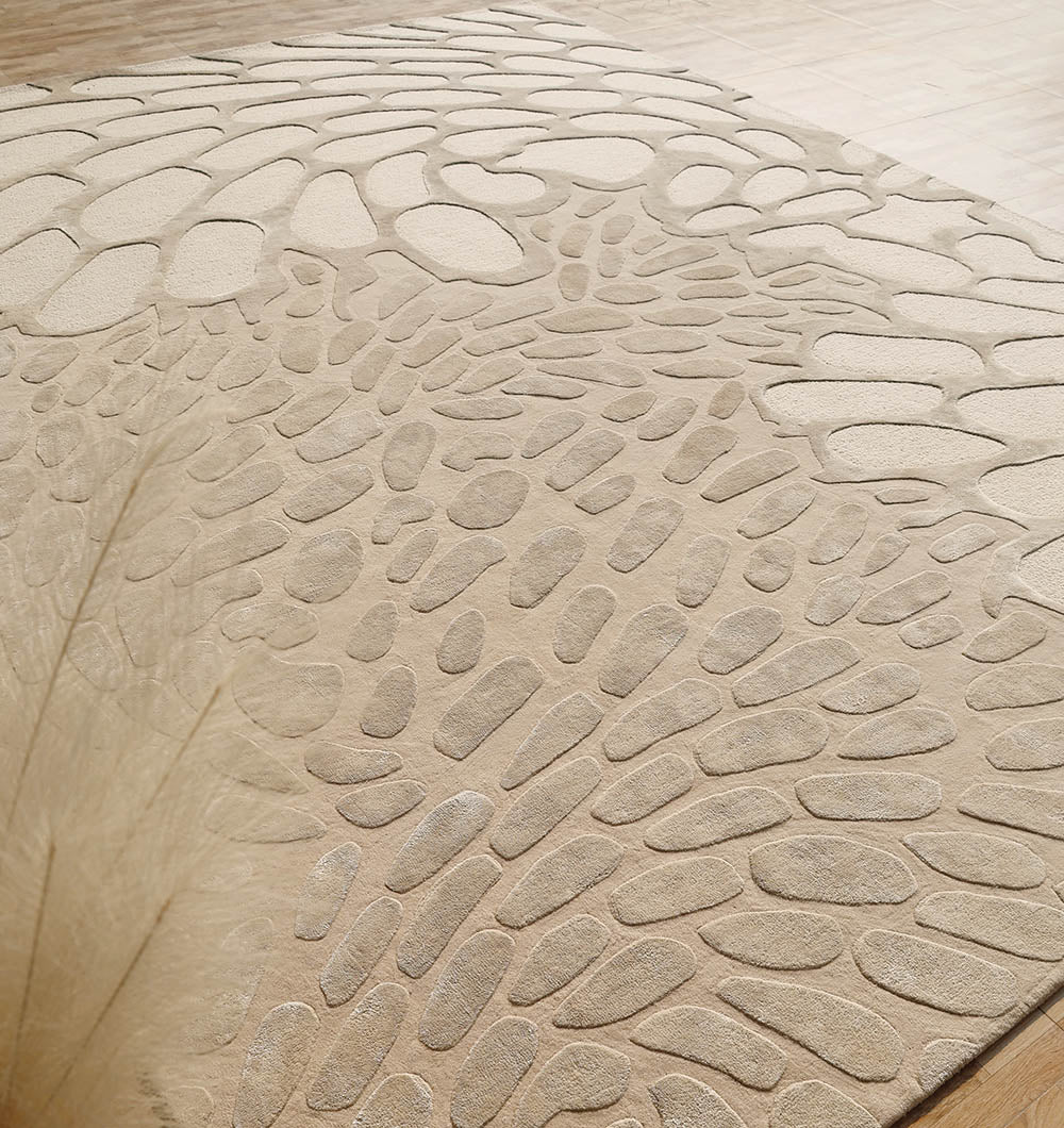 The RAMSHA HOME Organic Flow Hand-Tufted Rug – Soothing Beige Textured Elegance HTWV-134, made from wool and viscose, features a raised pebble-like pattern reminiscent of abstract stones or leaves on a light wooden floor.