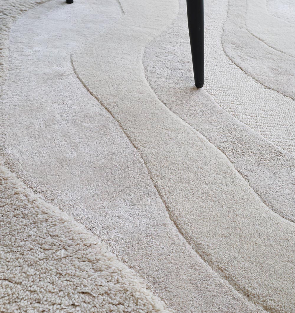 Close-up detailing the luxurious texture and meticulous attention to the handmade natural white rug's premium wool blend.