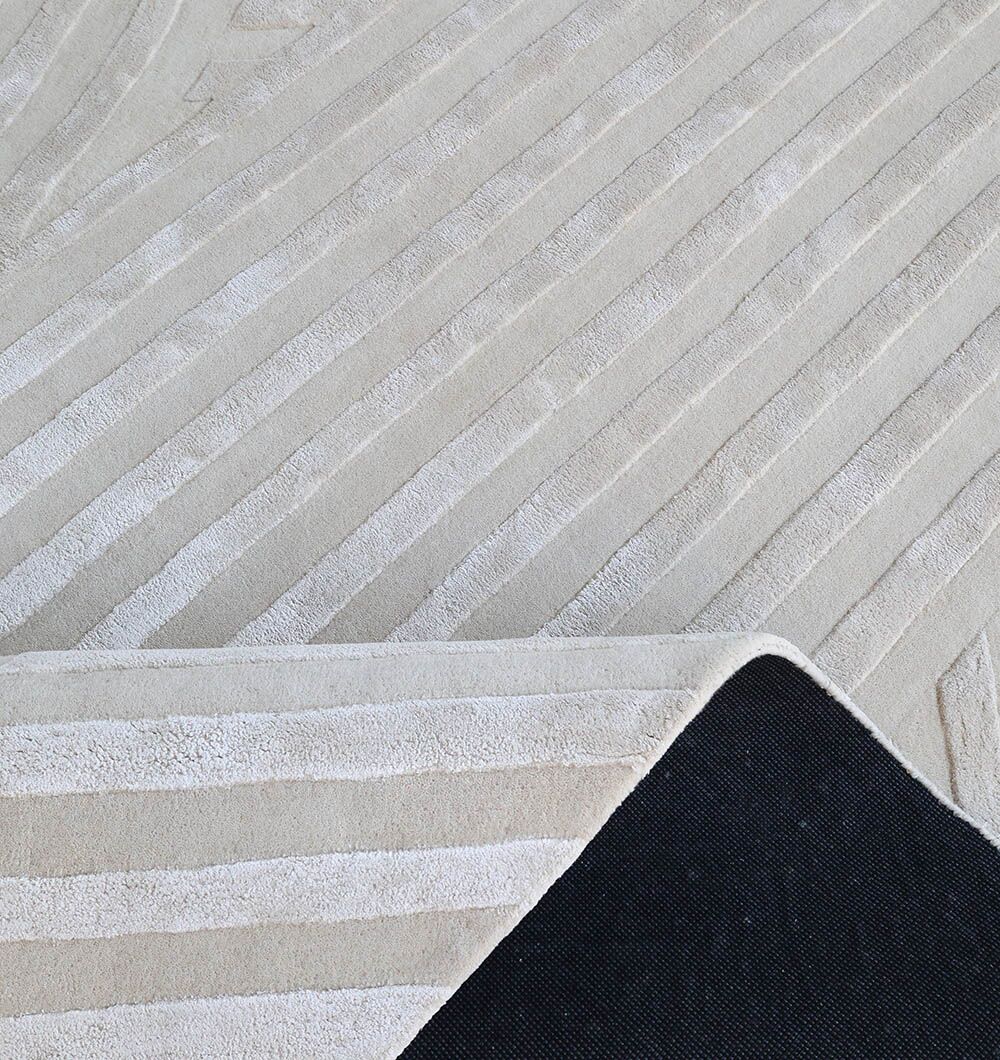 The RAMSHA HOME Natural White Handmade Area Rug (HTWV-142, 300x400 cm) features subtle raised linear patterns and is shown with one corner folded to display its black non-slip backing.